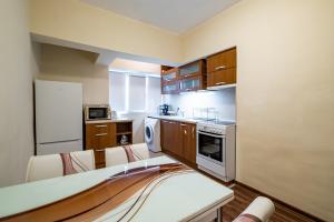 a kitchen with wooden cabinets and a white refrigerator at Primorski 2bdrm Central Apartment in Varna City