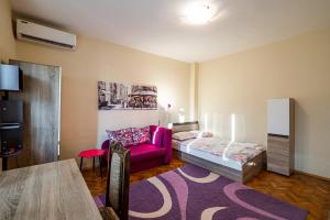 a bedroom with a bed and a purple couch at Primorski 2bdrm Central Apartment in Varna City