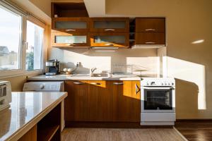 a kitchen with wooden cabinets and a white stove top oven at Primorski 2bdrm Central Apartment in Varna City +32 photos