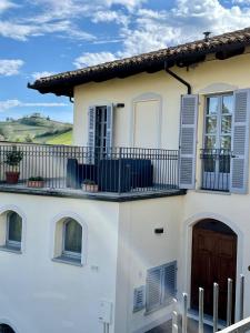 Casa blanca con balcón en Albergo Castiglione Langhe en Castiglione Tinella