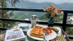 einen Teller Pizza auf einem Tisch mit einem Buch in der Unterkunft Tiger Sapa hotel in Sa Pa