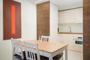 een keuken met een houten tafel en witte stoelen bij Benaki 85 Apartamento en plena naturaleza 