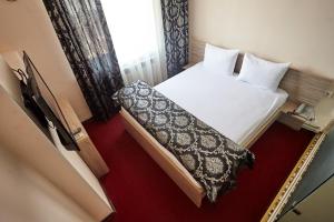 a small room with a bed and a window at KZO Hotel in Shymkent