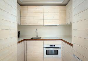 una cocina con armarios de madera y fregadero en Benaki 85 Apartamento en plena naturaleza, 