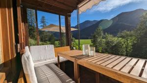 a table and chairs on a porch with a view of mountains at Idyllisches Berg-Chalet mit Panoramablick in Bayrischzell