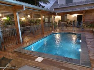 una piscina en una terraza con una casa en Haut de villa avec piscine en Saint-Joseph