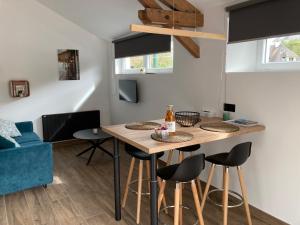 uma cozinha com uma mesa e bancos num quarto em L’Atelier em Arromanches-les-Bains