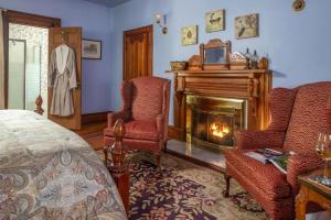 - une chambre avec une cheminée, deux chaises et un lit dans l'établissement Historic House! 12 acres 6 Suites BBQ, à Candler