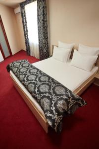 a large bed in a room with a window at KZO Hotel in Shymkent