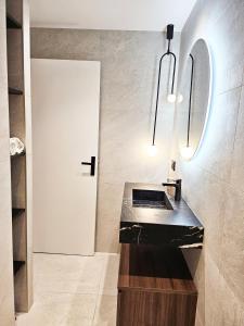 a bathroom with a black counter and a white door at Le petit Berriat - Grenoble centre in Grenoble
