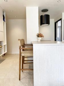 a kitchen with a counter and a table and a chair at Le petit Berriat - Grenoble centre in Grenoble +3 photos