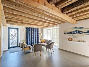 a living room with wooden ceilings and a table and chairs at Villa Panorama - 120m2, 8 pax, 6mn des pistes, rénové, plein sud in Puy-Saint-André