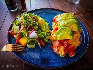 un plato azul con un plato de comida y una ensalada en Paapu House, en Chiang Mai