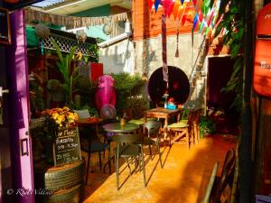 a restaurant with tables and chairs in a room at Paapu House in Chiang Mai