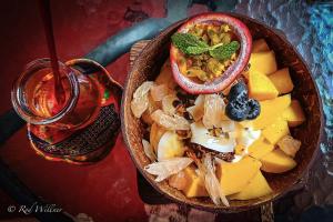 a bowl of food with fruit and a drink at Paapu House in Chiang Mai