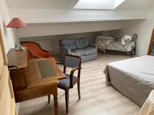 sypialnia z łóżkiem, biurkiem i kanapą w obiekcie Le Clos Ségur w mieście Leychert