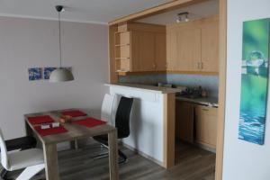 cocina con mesa, mesa pequeña y sillas en Ferienwohnung Haus Fernblick, 