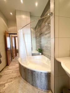un baño con bañera y lavabo en Focky City Apartments, en Viena 135 fotos más