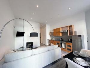 Una sala de estar con un sofá blanco y una cocina. en Focky City Apartments, en Viena