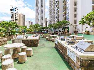 un patio con mesas y taburetes en una ciudad en Stunning 1BD a block away to Waikiki Beach Free Parking, en Honolulu