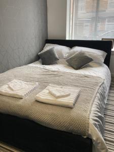 a bed with two folded towels on top of it at Apartment 8 - Luxury Living & free parking in Nottingham