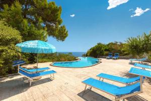 Un grupo de tumbonas azules y una piscina. en Villa Guendalina by Perle di Puglia, en Santa Cesarea Terme