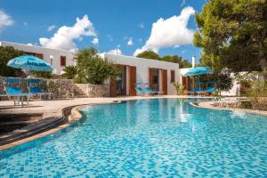 una piscina con sillas y sombrillas frente a una casa en Villa Guendalina by Perle di Puglia, en Santa Cesarea Terme