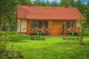 uma casa de madeira com setas a apontar para uma casa em Rentynówka em Gietrzwałd