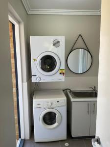 a laundry room with a washing machine and a mirror at Sea / lake townhouse in Rockingham