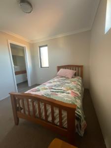 a bedroom with a bed with a quilt on it at Sea / lake townhouse in Rockingham