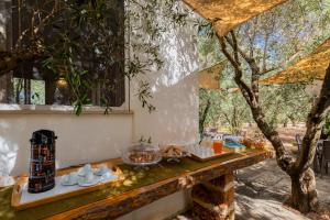 a table with food on it next to a tree at Domus mea salento Arazzo Giallo in Ugento