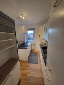 a kitchen with white cabinets and a sink and a window at 3 Zimmer Wohnung(1-6 Personen) in Leoben