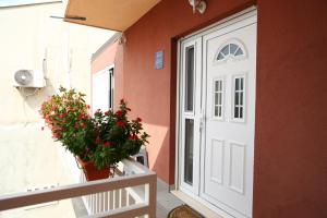 a white door and a plant on a balcony at Studio apartman Antonio in Metković