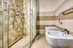 ein Bad mit einer Dusche, einem WC und einem Waschbecken in der Unterkunft Hotel Augustus in Rimini