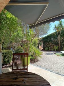a wooden bench sitting on a patio at Villa jardin et Spa in Taradeau
