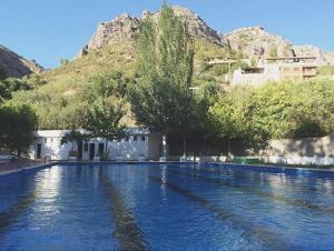 a large pool of water with a mountain in the background at Entre montañas in Dos Aguas