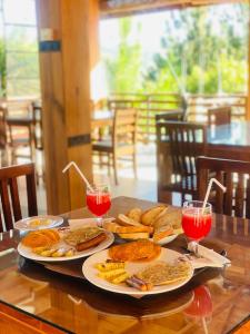 einen Tisch mit zwei Teller Essen und zwei Gläsern Wein in der Unterkunft La Seran Eco Resort in Bandarawela