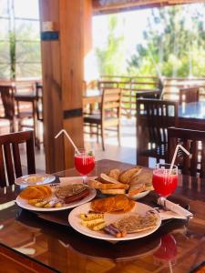 einen Tisch mit zwei Tellern Essen und zwei Getränken in der Unterkunft La Seran Eco Resort in Bandarawela