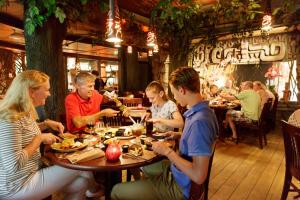 a group of people sitting at a table in a restaurant at Hotel Het Heijderbos by Center Parcs in Heijen