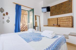 1 dormitorio con 1 cama con toallas en Isulidda Gaia Mare, en San Vito lo Capo