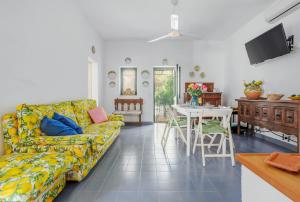een woonkamer met een bank en een tafel bij Isulidda Gaia Mare in San Vito lo Capo