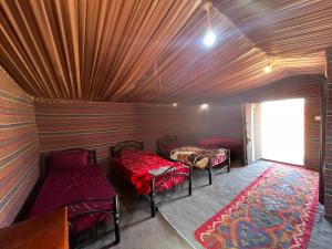 Cette petite chambre comprend 2 lits et une fenêtre. dans l'établissement Art Camp Wadi Rum, à Wadi Rum