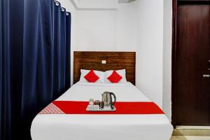 um quarto com uma cama com cortinas vermelhas e azuis em Flagship Pride Inn em Bangalore