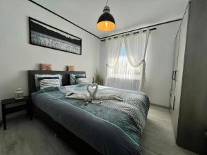 Un dormitorio con una cama grande con un cisne. en Le Clos fleuri, en Fauvillers