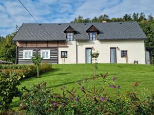 una casa en una colina con un patio verde en Luxusní apartmán s krbem - Kunratické Švýcarsko, en Kunratice