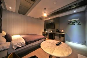 Un dormitorio con una cama y una mesa. en The Gentle Hotel en Busan