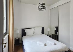 ein Schlafzimmer mit einem weißen Bett mit zwei Kissen darauf in der Unterkunft Le nid perché dans la doutre in Angers