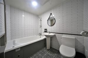y baño con bañera, aseo y lavamanos. en The Gentle Hotel en Busan