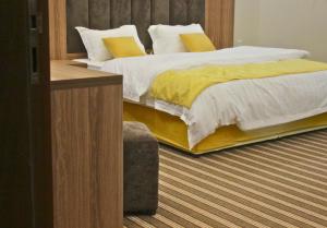 - une chambre avec 2 lits avec des draps jaunes et blancs dans l'établissement شقق كيان الحجاز, à Djeddah