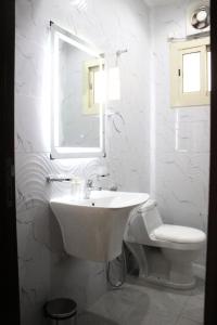 La salle de bains blanche est pourvue d'un lavabo et de toilettes. dans l'établissement شقق كيان الحجاز, à Djeddah